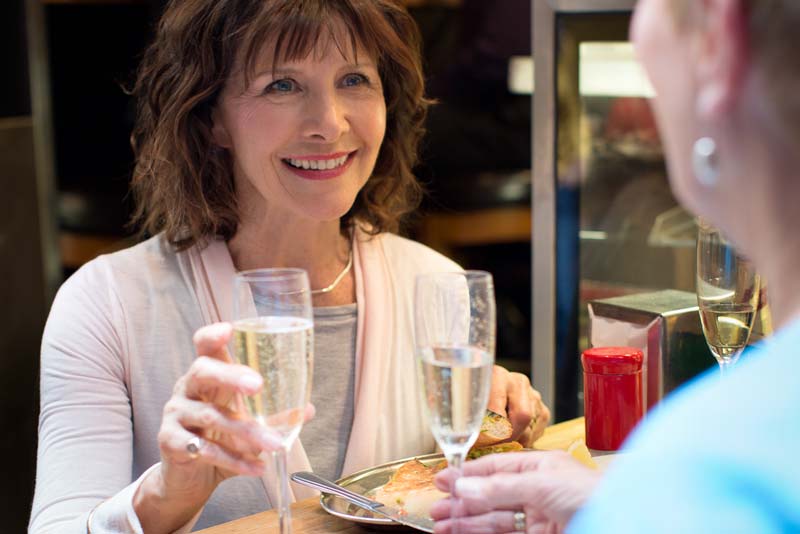 Friends with hearing aids for pensioners having lunch